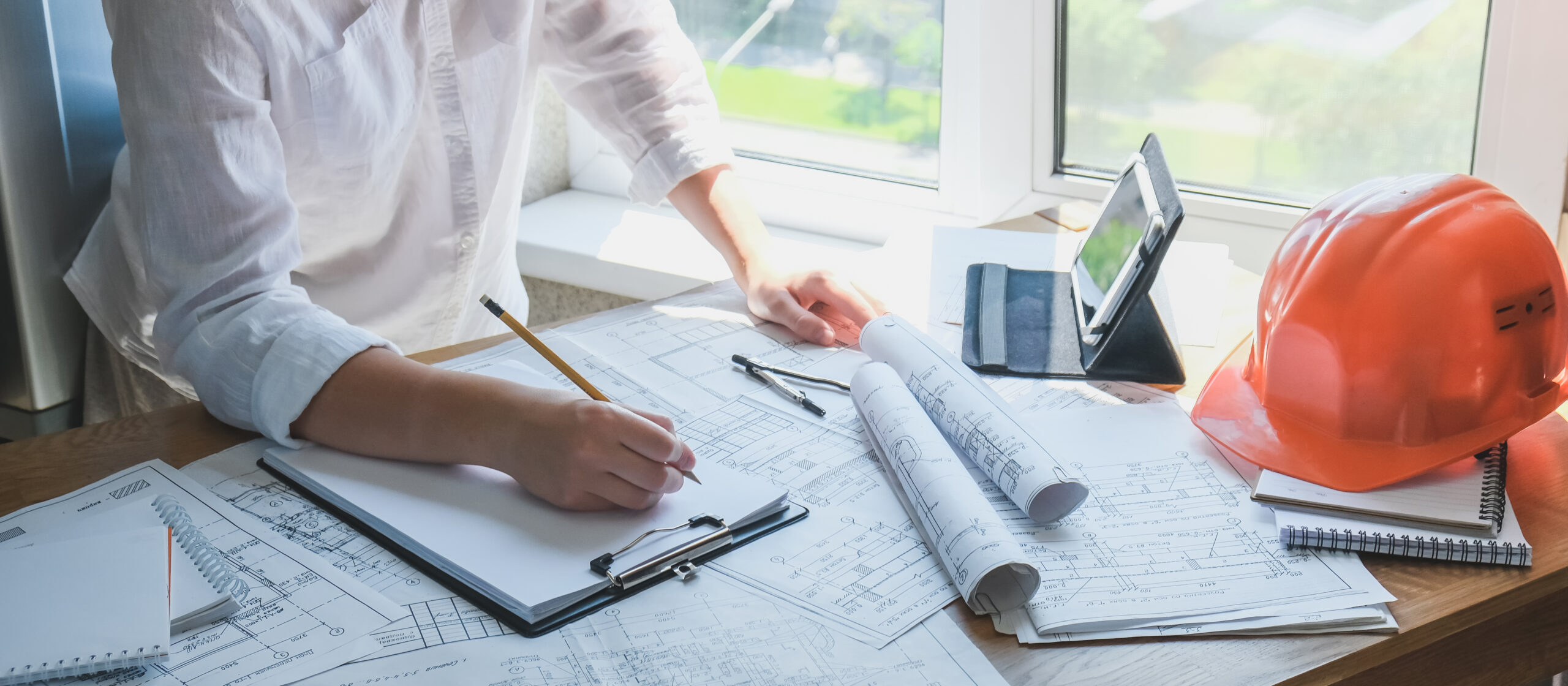 Architect works remotely from home in quarantine, lockdown covid 19 coronavirus. Remote work, stay home, new normality, social distance. Architect design working drawing sketch plans blueprints